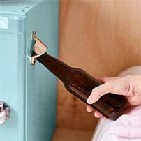 opening a beer bottle on the side door of a mini fridge