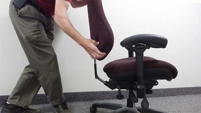 tall man adjusting a bodybilt ergonomic chair