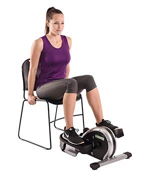 Woman using an elliptical trainer while sitting on a chair