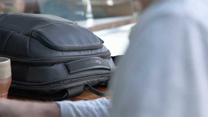 Bag at a home office with a man working on a computer in the foreground